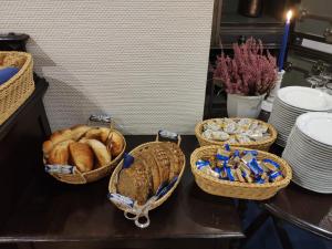 汉诺威Hotel Am Kamp的桌上有三篮子的面包,盘子