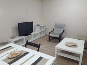 阿尔赫西拉斯Apartamentos Albeniz的客厅配有电视和桌椅