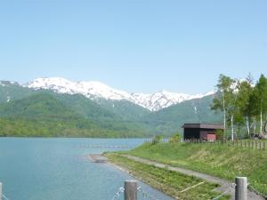 饭山市斑尾运动旅馆的享有以山脉为背景的湖泊美景