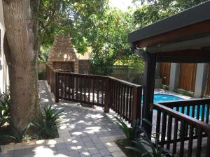 圣卢西亚Turaco Guest House的环绕着一棵树的木栅栏,靠近游泳池