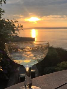 班戈北爱尔兰Perfect getaway, seafront home的酒杯坐在桌子上,背面是日落