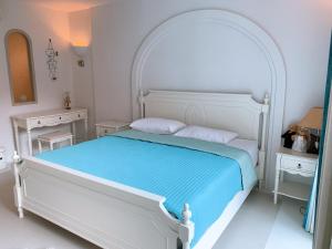考陶Chelona huahin beachfront condominium的白色卧室配有白色的床和2张桌子