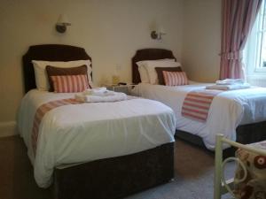 卡伦德Lubnaig Guest House的一间卧室配有两张带白色床单的床