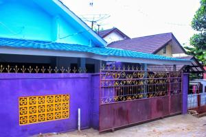 圣吉吉KJ Purple Gate SENGGIGI的房屋前的紫色围栏