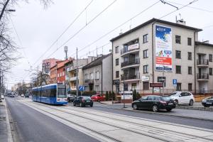 克拉科夫Bronowicka Premium Apartment - 52m2 with private parking的一辆蓝色的巴士开往城市街道,汽车