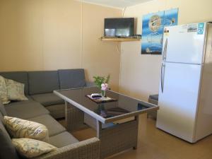 朱里恩湾朱利安海滨度假屋的带沙发和白色冰箱的客厅