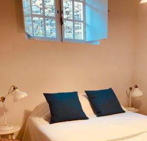 莫托拉Casas de Mértola 33的一间卧室配有一张带蓝色枕头的床和一扇窗户。