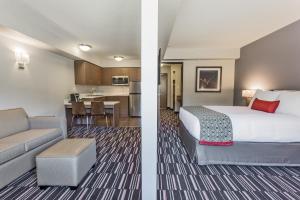 圣约翰堡Microtel Inn & Suites by Wyndham Fort Saint John的酒店客房带一张床和一个厨房