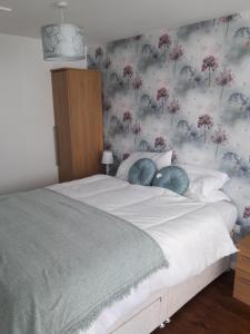 伊夫舍姆Bell Inn的一间卧室配有一张带花卉壁纸的床
