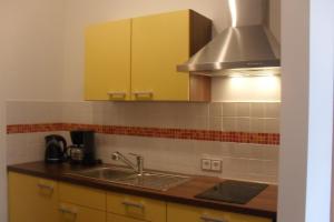 MuldensteinPension Am Steinberg的厨房配有黄色橱柜和水槽