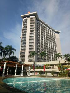 马尼拉Century Park Hotel的一座大型建筑,前面设有一个游泳池