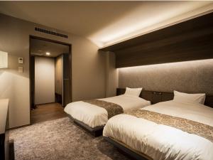 函馆汤之川渚太子酒店的一间酒店客房,设有两张床和走廊