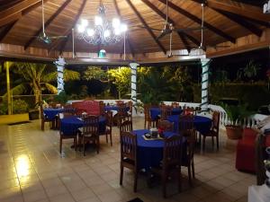 LomaHotel Grosseto Palma Real的餐厅设有蓝色的桌椅和吊灯。