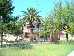 耶泽拉Apartments Nicole的红房子前面的棕榈树