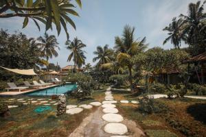 吉利阿尔斯佳村庄酒店的一个带游泳池和棕榈树的度假村