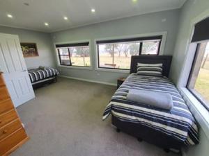 芒特甘比尔Pleasant Hill BnB的一间卧室设有一张床和两个窗户。