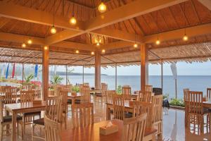 艾湄湾Seamount Hotel Amed的海滩上的餐厅,配有桌椅