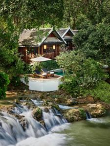 琅勃拉邦红木琅勃拉邦酒店的河边的房屋,有瀑布