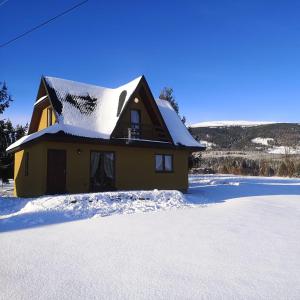 Lipnica WielkaBabiogórski Raj的雪中带雪盖屋顶的房子