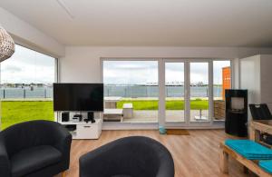 奥尔本尼兹Marina Lodge的客厅配有平面电视和大窗户。