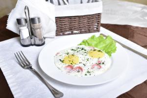 巴尔瑙尔机场酒店的桌上的鸡蛋和沙拉的白盘