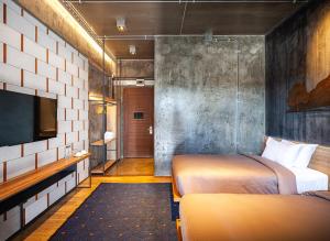 洛坤府Navakitel Design Hotel的一间酒店客房,设有两张床和电视