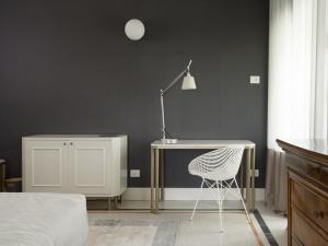 SantʼOmeroVilla Corallo的一间卧室配有一张桌子、一盏灯和一把椅子
