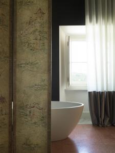 SantʼOmeroVilla Corallo的带浴缸的浴室和窗户。