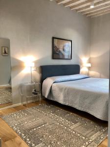 阿雷佐Appartamento Mariapaola的一间卧室配有一张床、两盏灯和地毯。