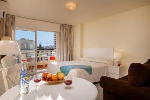 多列毛利诺斯努克里奥克里斯塔尔公寓的酒店客房,配有一张床和一张桌子,还有一碗水果