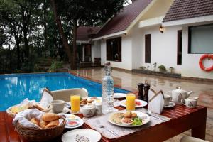 马迪凯里The IBNII - Eco Luxury Resort的一张桌子,上面有食物,放在游泳池边