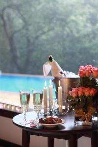 马迪凯里The IBNII - Eco Luxury Resort的一张带蜡烛和酒杯的桌子和一张玫瑰桌