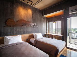 洛坤府Navakitel Design Hotel的一间卧室设有两张床和窗户。