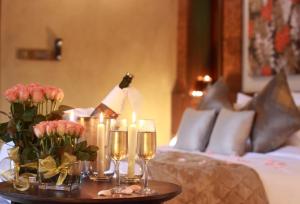 马迪凯里The IBNII - Eco Luxury Resort的床上的桌子上放着蜡烛和鲜花
