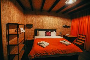 卡兹贝吉Wooden Hotel Kazbegi的一间卧室配有一张带红色毯子的床