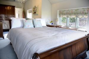 安伯利Spring Cottage的卧室配有一张带白色床单和枕头的大床。
