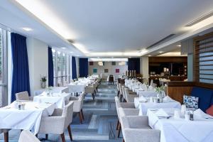 伦敦千禧国际切尔西足球俱乐部国敦酒店的一间设有白色桌椅的用餐室