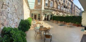 巴塞罗那Hostal La Terrassa的一座带桌椅的户外庭院和一座建筑