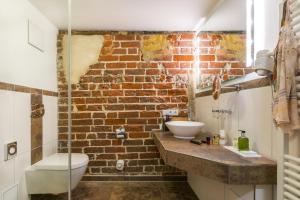 施特拉尔松德施特拉尔松斯科勒霍夫浪漫酒店的一间带水槽和砖墙的浴室