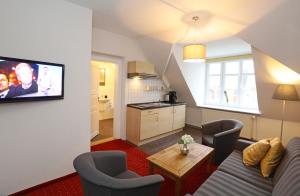 施特拉尔松德弗泽恩市场公寓式酒店的带沙发和椅子的客厅以及厨房。
