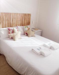 希奥Casa apartamento a pie de playa Areabrava - en Cangas - Hio -Galicia- España的一张带枕头和毛巾的白色床