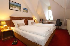 施特拉尔松德弗泽恩市场公寓式酒店的卧室配有一张白色大床
