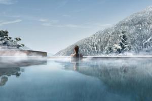 平佐洛Lefay Resort & SPA Dolomiti的坐在山里无边游泳池里的人