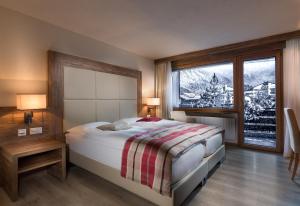 采尔马特采尔马特国宾酒店的一间卧室设有一张床和一个大窗户