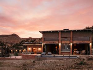 LuckhoffEco Karoo Mountain Lodge的日落时分沙漠中的房屋