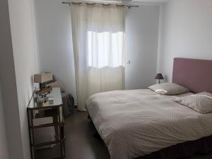 普罗普里亚诺波尔图钢琴公寓的一间小卧室,配有床和窗户