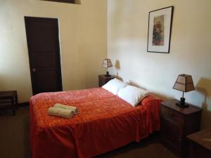 库斯科埃尔图科酒店的一间卧室配有一张红色床罩的床