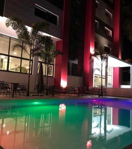 达喀尔Hotel L'Adresse Dakar的一座游泳池,在晚上在建筑物前