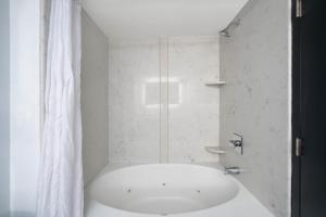 罗利La Quinta by Wyndham Raleigh Downtown North的带淋浴和盥洗盆的白色浴室