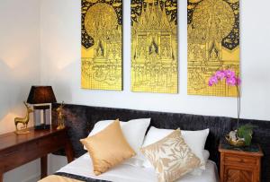 乌尔加特暹罗卡斯特尔酒店的卧室的墙壁上装饰着黄色和黑色艺术品。